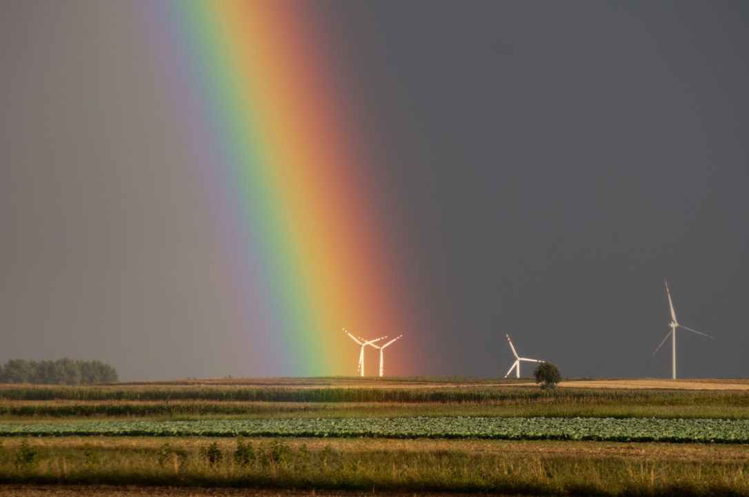 landscape photography of field with wind mill with rainbow